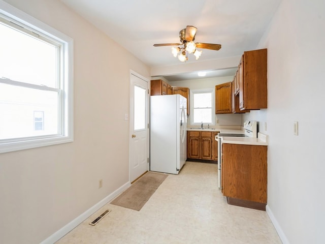 kitchen featuring ceiling fan, white fridge, plenty of natural light, and sink