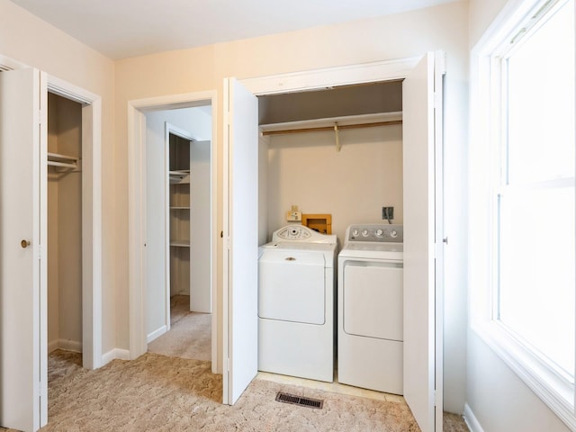 clothes washing area featuring separate washer and dryer and light colored carpet