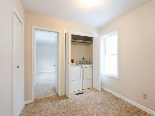 washroom with washer and dryer and light colored carpet