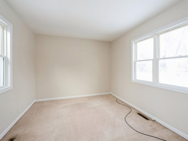 spare room with carpet flooring and plenty of natural light