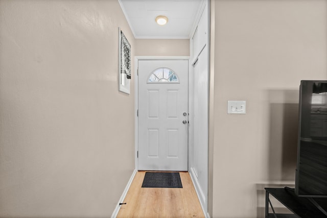 entryway with light hardwood / wood-style floors and ornamental molding