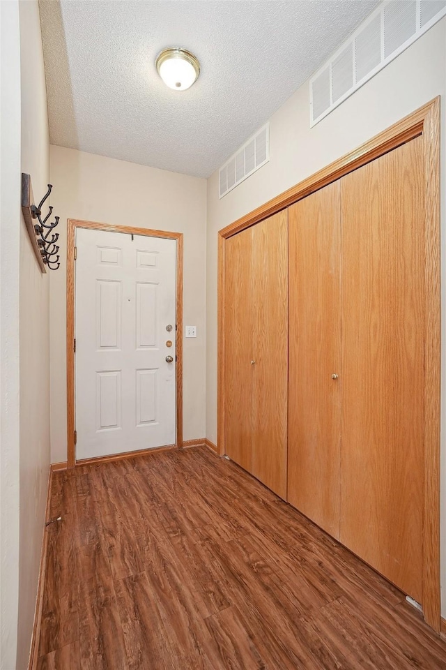 entrance foyer featuring dark hardwood / wood-style flooring and a textured ceiling