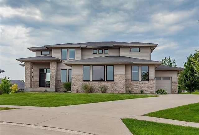 prairie-style house featuring a garage and a front yard