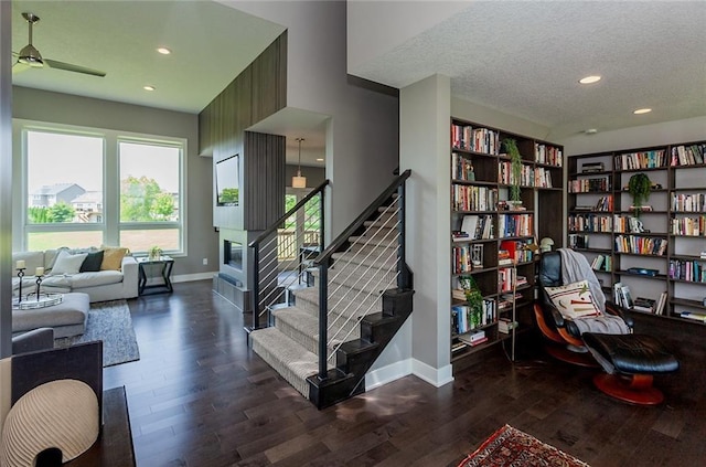 staircase featuring hardwood / wood-style flooring, ceiling fan, and a textured ceiling