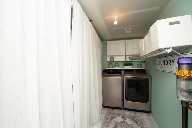 clothes washing area with cabinets and independent washer and dryer