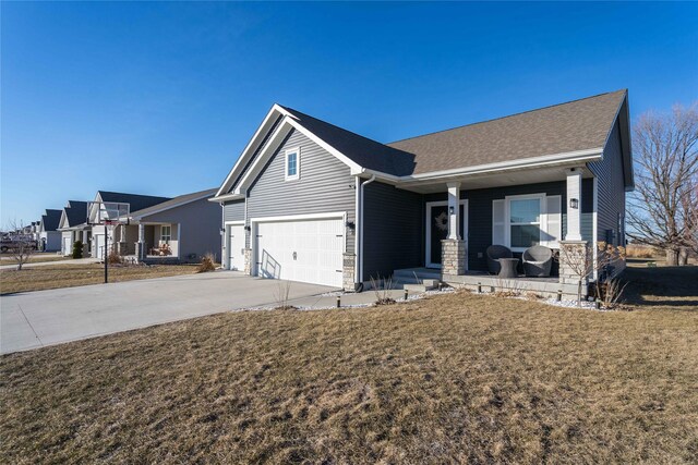 view of front of house featuring a porch, a garage, and a front yard