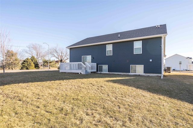 rear view of house featuring a wooden deck, a lawn, and central air condition unit