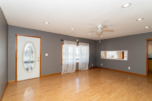 entryway featuring ceiling fan, a wealth of natural light, a textured ceiling, and light hardwood / wood-style flooring