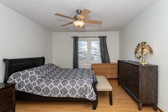 bedroom featuring ceiling fan, a textured ceiling, and light hardwood / wood-style floors