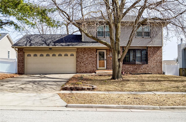 view of front of house with driveway, brick siding, an attached garage, and fence