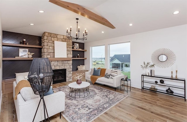 living room with a stone fireplace, an inviting chandelier, wood walls, beamed ceiling, and light wood-type flooring