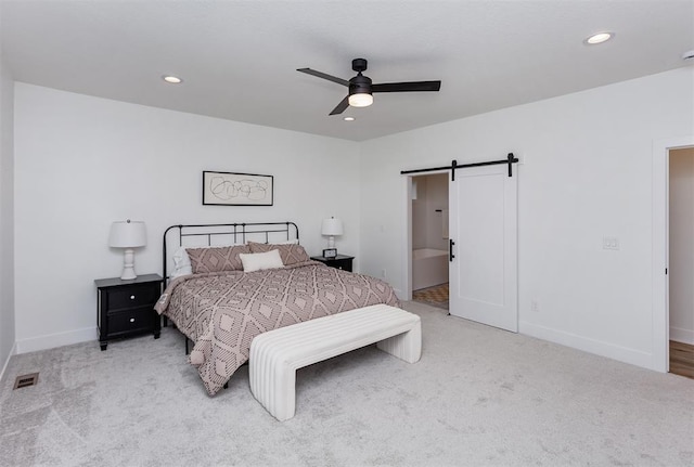 carpeted bedroom featuring a barn door and ceiling fan