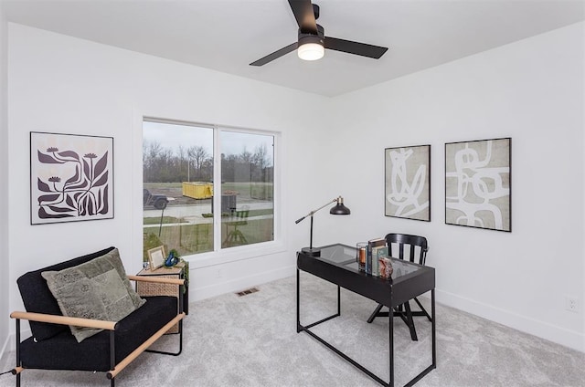 carpeted home office featuring ceiling fan