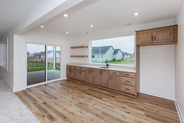 kitchen with sink and light hardwood / wood-style flooring