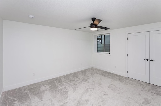 unfurnished bedroom featuring light carpet, ceiling fan, and a closet