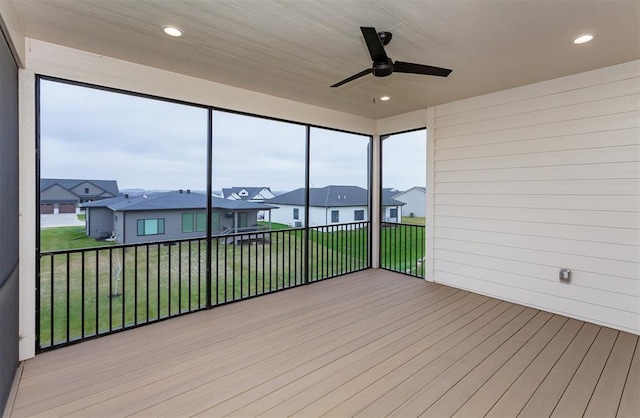 unfurnished sunroom with ceiling fan