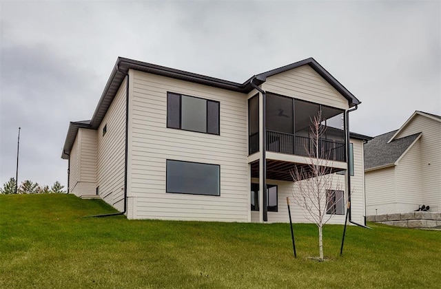 rear view of house with a sunroom and a yard