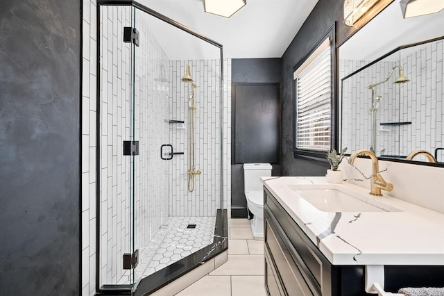 bathroom featuring toilet, vanity, tile patterned floors, and an enclosed shower