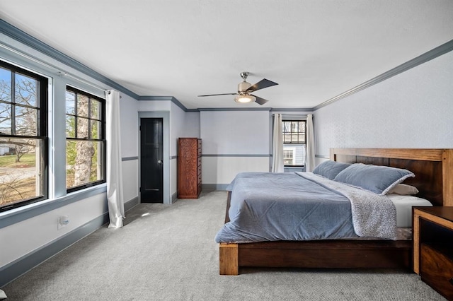 bedroom featuring light carpet, multiple windows, ceiling fan, and crown molding