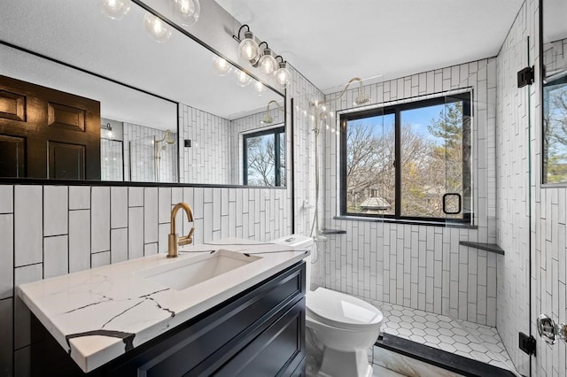 bathroom featuring tiled shower, vanity, and toilet