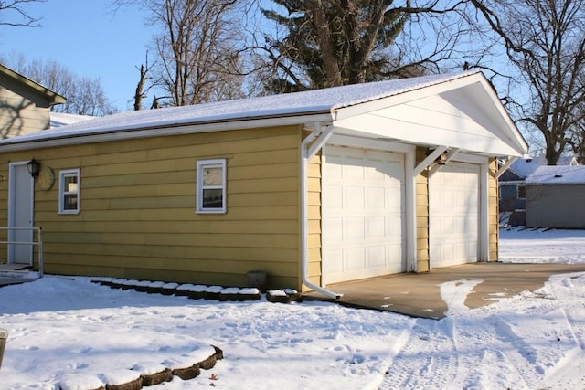 view of snow covered exterior featuring a garage