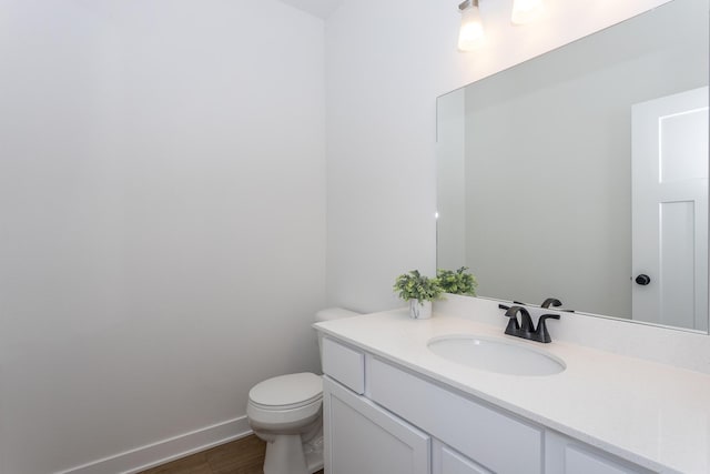 bathroom featuring toilet, hardwood / wood-style floors, and vanity