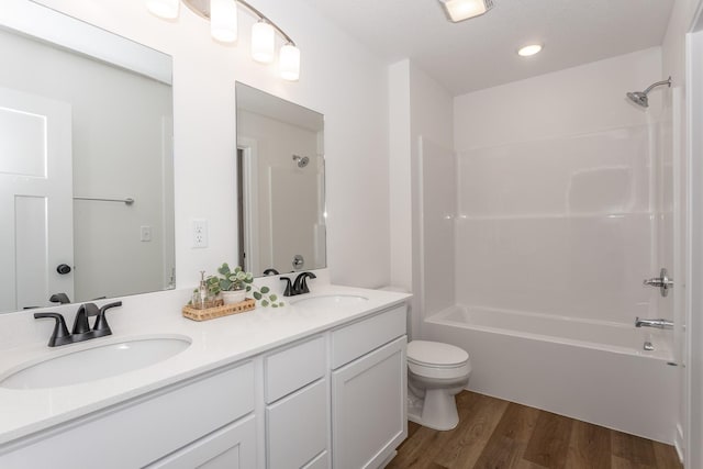 full bathroom with toilet, wood-type flooring, vanity, and bathing tub / shower combination