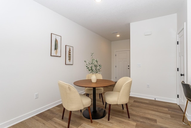 dining space with hardwood / wood-style flooring