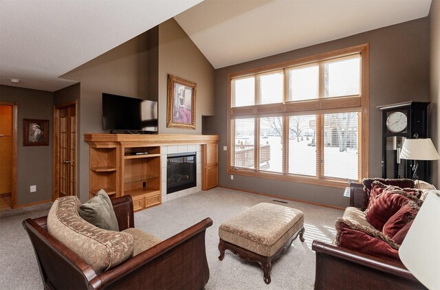 living room featuring vaulted ceiling, carpet, and a fireplace