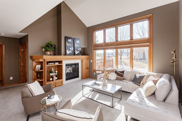 living area featuring carpet floors, high vaulted ceiling, and a tile fireplace