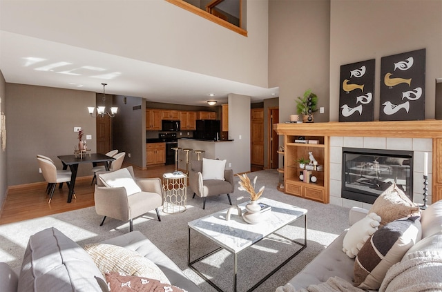 living area with a notable chandelier and a tiled fireplace