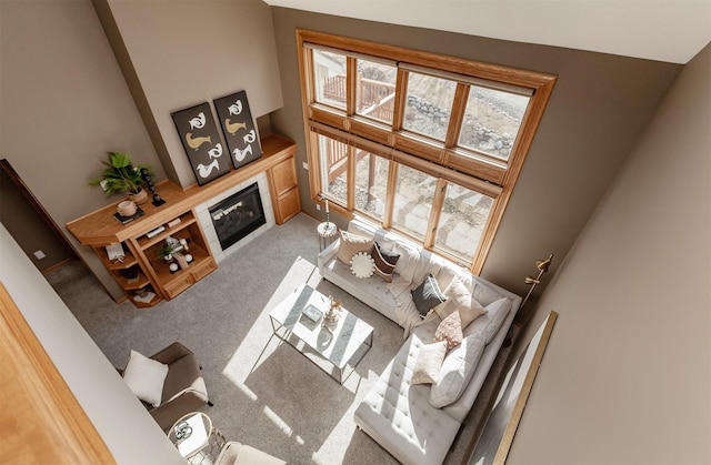 carpeted living area featuring a glass covered fireplace