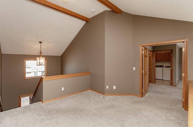 empty room featuring lofted ceiling with beams, baseboards, washer and dryer, and light colored carpet