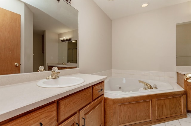 bathroom with tile patterned flooring, a tub with jets, and vanity