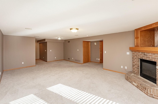 unfurnished living room with visible vents, a fireplace, baseboards, and light colored carpet