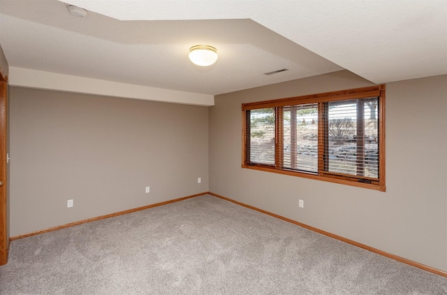 carpeted empty room with visible vents and baseboards