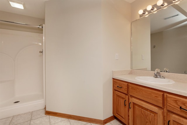 full bathroom featuring tile patterned flooring, visible vents, vanity, baseboards, and a stall shower