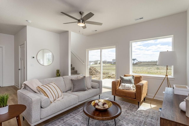 living room with hardwood / wood-style flooring, a wealth of natural light, and ceiling fan