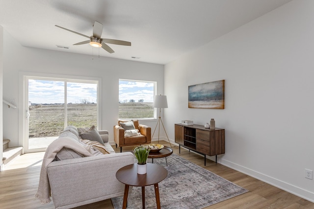 living room with light wood-type flooring and ceiling fan