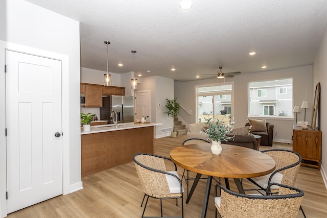 dining space featuring a textured ceiling, recessed lighting, visible vents, stairway, and light wood-type flooring