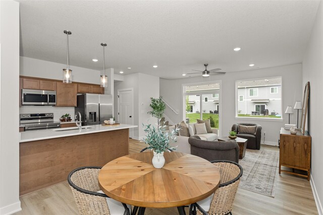 234 NW Waverly Dr, Waukee, IA 50263 - dining space featuring light wood-style floors, a ceiling fan, recessed lighting, and baseboards