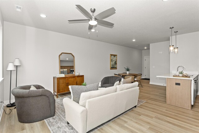 234 NW Waverly Dr, Waukee, IA 50263 - living room with light wood finished floors, ceiling fan, recessed lighting, arched walkways, and baseboards