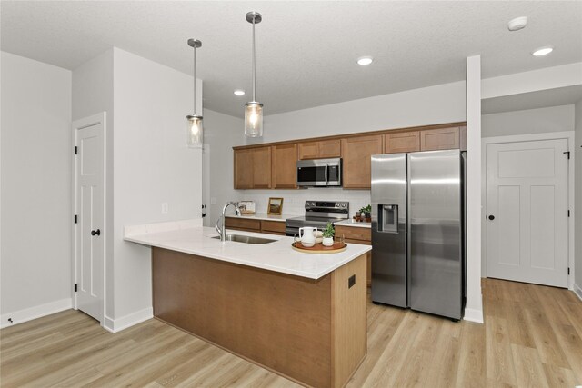 234 NW Waverly Dr, Waukee, IA 50263 - kitchen with appliances with stainless steel finishes, light wood finished floors, a sink, brown cabinets, and a peninsula