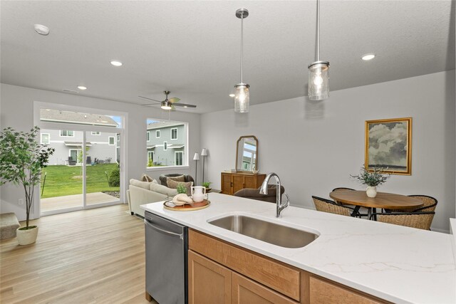 234 NW Waverly Dr, Waukee, IA 50263 - kitchen with stainless steel dishwasher, a sink, decorative light fixtures, ceiling fan, and light wood-style floors