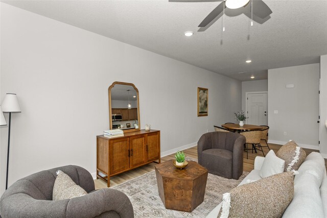 234 NW Waverly Dr, Waukee, IA 50263 - living area with light wood-style flooring, ceiling fan, recessed lighting, baseboards, and arched walkways