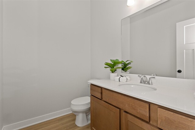 234 NW Waverly Dr, Waukee, IA 50263 - half bath featuring toilet, vanity, wood finished floors, and baseboards