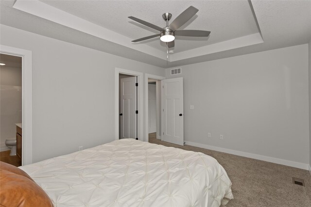 234 NW Waverly Dr, Waukee, IA 50263 - bedroom featuring a raised ceiling, baseboards, carpet flooring, ensuite bathroom, and a ceiling fan