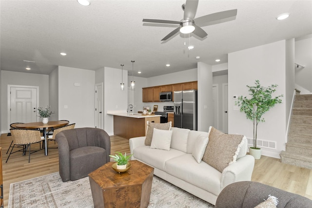 230 NW Waverly Dr, Waukee, IA 50263 - living room with light wood-style floors, stairway, ceiling fan, baseboards, and recessed lighting