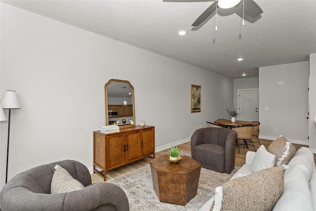230 NW Waverly Dr, Waukee, IA 50263 - living area with light wood-style flooring, ceiling fan, recessed lighting, baseboards, and arched walkways