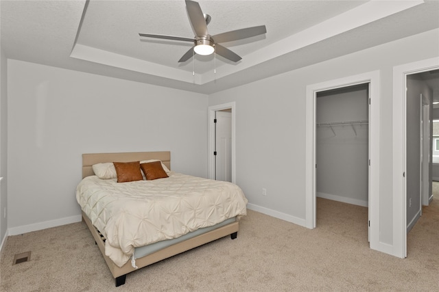 230 NW Waverly Dr, Waukee, IA 50263 - bedroom with a raised ceiling, carpet floors, a walk in closet, a closet, and baseboards